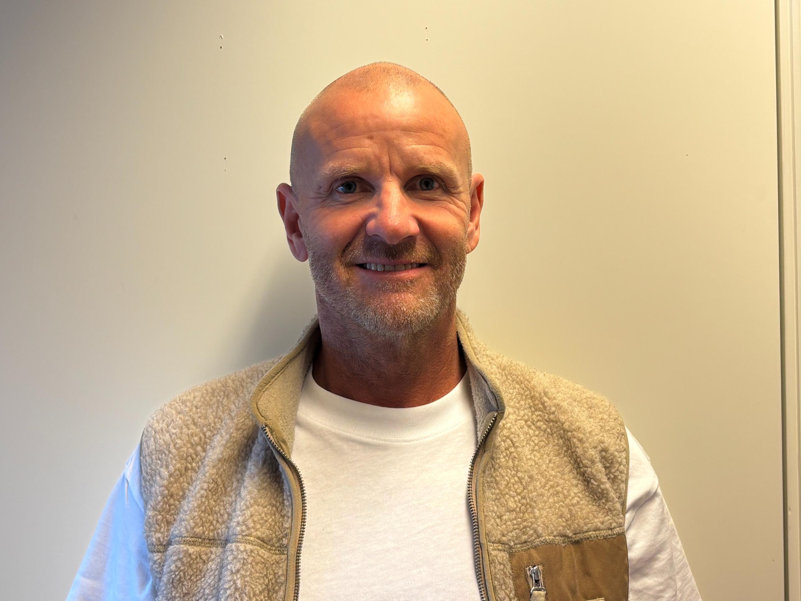 Mann med skjegg og beige vest